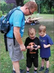  ?? PHOTOS BY MICHILEA PATTERSON — DIGITAL FIRST MEDIA ?? Raymond Rose looks over his sons while they use the Pokemon Go app on his phone at Memorial Park in Pottstown.