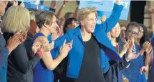  ?? CHRIS CHRISTO / BOSTON HERALD ?? BLUE WAVE: Sen. Elizabeth Warren raises a hand to acknowledg­e cheers of supporters Tuesday night at her Fairmont Copley Plaza victory party.