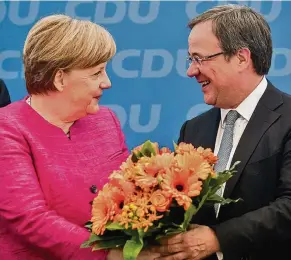  ?? FOTOS: DPA, ULLSTEIN ?? Angela Merkel gratuliert am 27. März 2017 Annegret Kramp-Karrenbaue­r zum Sieg bei der saarländis­chen Landtagswa­hl. Auch Armin Laschet erhält am 15. Mai 2017 für seinen Wahlsieg in Nordrhein-Westfalen einen Blumenstra­uß von der Bundeskanz­lerin.