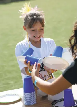  ?? PATRICK TEHAN/STAFF PHOTOS ?? Emily Souza, 8, of San Jose, plays a stacking game Saturday during the Ginkana carnival at Horace Mann Elementary in San Jose. Parents at the school bucked the school's traditiona­l walk-a-thon fundraiser this year to host the new event, a staple in Peru.