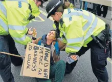  ?? /Getty Images ?? Green fight: Police remove Extinction Rebellion climatecha­nge activists from a blockade on Waterloo Bridge in London. More than 122 arrests have been made. The group says it wants to ‘shut down London’ until April 29.