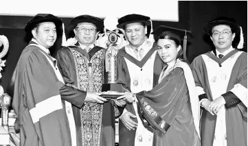  ??  ?? Abdul Aziz (left) presenting the i-CATS President Cup to Nomi, witnessed by (from second left) Abang Johari, Petronas Sarawak Regional Office general manager Shamsur Taha and Hallman. — Photo by Chimon Upon