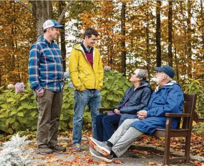  ?? OLIVER PARINI / THE NEW YORK TIMES ?? Joan and Eric Thompson (seated) moved into a retirement community in Shelburne, Vermont, where to be closer to sons Josh (left) and Matt. Some older adults are skipping a sun-drenched retirement and, thinking about potential future decline, choosing to live near children and grandchild­ren.