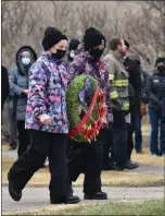  ?? ?? Two cadets carry a wreath to the cenotaph during the outdoor Remembranc­e Day service in Swift Current.