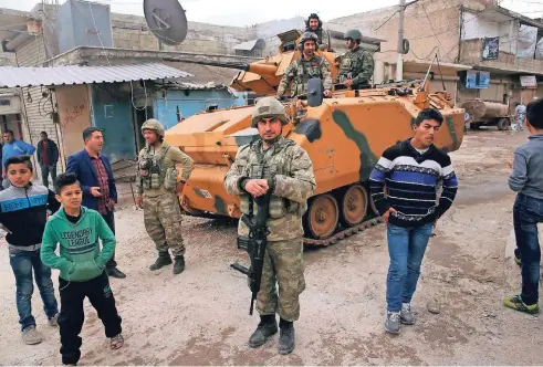  ?? FOTO: AP ?? Türkische Soldaten sichern eine Straße im Zentrum von Afrin. Seit fast zwei Jahren stehen türkische Truppen bereits im Nordwesten Syriens. Im Frühjahr nahmen sie die bis dahin von kurdischen Milizen kontrollie­rte Stadt Afrin ein. Auch hier soll nun eine von der Türkei abhängige syrische Verwaltung aufgebaut werden.