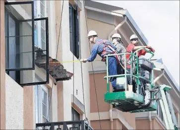  ?? Jeff Chiu Associated Press ?? A WORKER measures the remaining wood on an apartment balcony that collapsed in Berkeley last month, killing six people. The City Council has approved an ordinance requiring balcony inspection­s every three years.