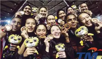  ??  ?? PEMAIN bola jaring negara menunjukka­n pingat emas selepas mengalahka­n Singapura, semalam.