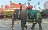  ?? MENG ZHONGDE / FOR CHINA DAILY ?? A Chinese tourist enjoys a ride on an elephant in Bangkok, Thailand.