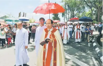  ??  ?? Michael (front) leads the Stations of the Cross procession at St Thomas’ Cathedral. — Photos by Jeffery Mostapa