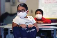  ?? The Associated Press ?? ■ A summer school student wears a protective mask due to concerns of the COVID-19 virus pandemic while listening to instructio­n on Aug. 4, 2021, at the E.N. White School in Holyoke, Mass. Students and staff at public schools in Massachuse­tts will no longer be required to wear face coverings while indoors starting Feb. 28, state officials said Wednesday.