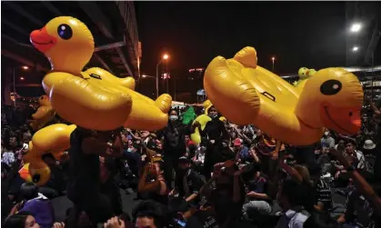  ?? Images ?? Pro-democracy protesters hold up large inflatable yellow ducks during a rally in Bangkok in November 2020. Photograph: Lillian Suwanrumph­a/AFP/Getty