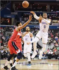  ?? AP PHOTO / NICK WASS ?? Oklahoma City Thunder guard Russell Westbrook (0) passes the ball over Washington Wizards forward Otto Porter Jr., left, during the first half of an NBA basketball game Friday in Washington. At rear is Thunder center Steven Adams (12), of New Zealand.