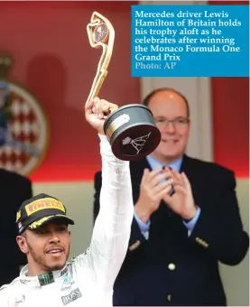  ??  ?? Mercedes driver Lewis Hamilton of Britain holds his trophy aloft as he celebrates after winning the Monaco Formula One Grand Prix Photo: AP