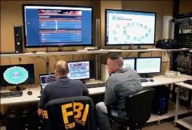  ?? Lake Fong/Post-Gazette ?? Agents with FBI Pittsburgh’s cyber squad monitor criminal activities at the National Cyber Forensic and Training Alliance Center in South Oakland.