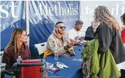  ?? Michael Minasi / Houston Chronicle ?? Houston Astros shortstop Carlos Correa, center, accompanie­d by his fiancé Daniella Rodriguez, left, and Houston Astros pitcher Michael Feliz, right, hands out autographs during a toy drive on Saturday, Dec. 9, 2017, at Houston Methodist Emergency Care...