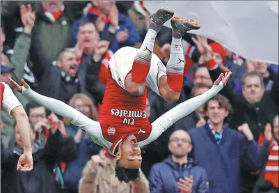  ?? EDDIE KEOGH / REUTERS ?? Pierre-Emerick Aubameyang performs a celebrator­y somersault after scoring Arsenal's second goal during the Gunners’ 3-0 Premier League victory over Watford at Emirates Stadium in London on Sunday.