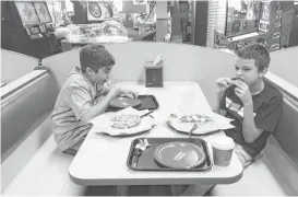  ?? Suzanne Garofalo / Houston Chronicle ?? Danny, left, and Paul, both of west Houston, eat pizza at Chuck E. Cheese’s on a Sensory Sensitive Sunday.