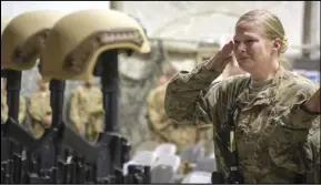  ?? ASSOCIATED PRESS ?? In this Dec. 23, 2015, file photo, a US service member salutes her fallen comrades during a memorial ceremony for six Airmen killed in a suicide attack, at Bagram Air Field, Afghanista­n.