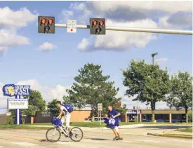  ??  ?? Solid red lights tell motorists to stop after two Highland East Junior High School students activated the new crossing signal.