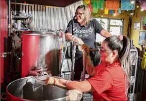  ?? ?? Jessica Fierro and her daughter, Kassy Fierro, transfer a beer during the brewing process at Atrevida Beer Co. in Colorado Springs.