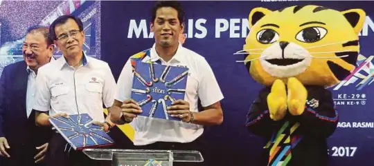  ?? [ FOTO LUQMAN HAKIM ZUBIR/BH ] ?? Khairy dan Roslan (dua dari kiri) melakukan gimik pelancaran Coffee Table Book 'The Sticks' pada pada Majlis Penyerahan Tajaan TNB untuk Sukan SEA KL2017 di ibu pejabat TNB, kelmarin.