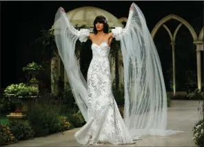  ?? AP/MANU FERNANDEZ ?? A model wears a creation from Pronovias in this file photo taken during the 2018 Barcelona Bridal fashion week in Barcelona, Spain. From dumping the bouquet and garter tosses to statement hats instead of veils, today’s brides and grooms are going their own way.