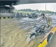  ?? BIPLOV BHUYAN/HT PHOTO ?? A man pushes his motorcycle across a water-logged stretch near AIIMS in New Delhi on Saturday.