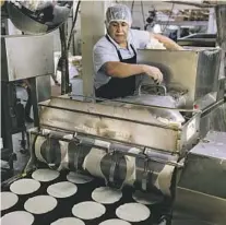  ?? ?? Esteban Conde loads the tortilla press with fresh masa at La Gloria Tortilla Factory
Los Angeles Times