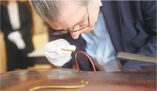  ?? AMY HERZOG/MORNING CALL FILE PHOTO ?? A cello, built by Moravian missionary John Antes, is examined in February for authentici­ty at the Moravian Historical Society, which is looking for electronic items to help it continue to present historic artifacts and culture to the area.