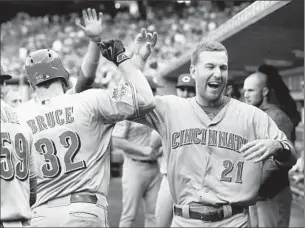  ?? Carlos Osorio
Associated Press ?? TODD FRAZIER (21), who hit two home runs in the game, congratula­tes Cincinnati Reds teammate Jay Bruce (32), who also hit one against the Detroit Tigers on June 16.