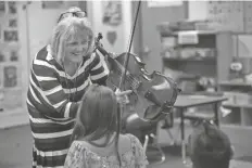  ?? FOTO GENESIS ALVARADO/CRONKITE NOTICIAS ?? CANDICE HALBERG, maestra invitada en la Escuela Primaria Rancho Santa Fe en Avondale, les explica a sus alumnos que la firma del fabricante de violas está dentro de la caja y solo puede ser vista a través del agujero en forma de f el 2 de marzo de 2022.