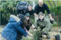  ?? (Courtesy) ?? SPECIAL IN UNIFORM participan­ts and volunteers plant a tree in honor of Tu Bishvat.