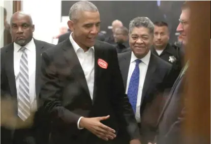  ?? | GETTY IMAGES ?? Former President Barack Obama, accompanie­d by Cook County Circuit Court Chief Judge Timothy Evans ( blue tie), extends his hand as he attends Cook County jury duty at the Daley Center on Wednesday.