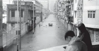  ?? — Gambar AFP ?? BERWASPADA: Penduduk meninjau keadaan banjir akibat ombak ribut menjelang kemaraan Mangkhut di Macau, semalam.