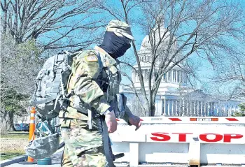  ?? — AFP photo ?? A members of the National Guard walks near the Capitol Building on Capitol Hill in Washington, DC.