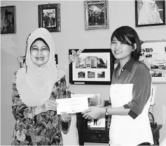  ??  ?? DAS representa­tive Mary Tang (right) receiving a cheque for RM10,000 from Fatimah.