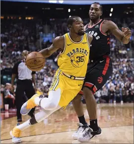  ?? NATHAN DENETTE — THE ASSOCIATED PRESS ?? Kevin Durant drives around the Raptors’ Kawhi Leonard. Durant scored 18 points in the third quarter and sent the game into overtime with two 3-pointers in the final 45 seconds.