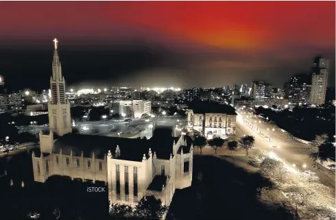  ?? ISTOCK ?? STRIKE A POSE: The Maputo skyline at night with the cathedral in the foreground, right, and model Thami Gumede works it in Ephymol during a beach photo shoot