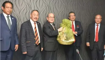  ??  ?? Uggah (centre) presents a memento comprising local products to Dr Abd Latiff (second right) as (from left) Dr Abdul Rahman, Sagah and Henry look on.