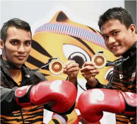  ??  ?? Packing a punch: Ain Kamaruddin (right) and Mohd Ali Yaakub posing with their gold medal yesterday.