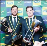  ??  ?? South Africa captain Duane Vermeulen (left), with coach Rassie Erasmus hold trophies after their media conference upon their arrival at OR Tambo Internatio­nal Airport in Johannesbu­rg, South Africa on Aug 12. (AP)