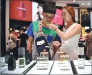  ?? XINHUA ?? Tourists buy perfume at a duty-free shop in Sanya, Hainan province.