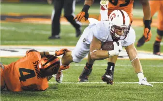  ?? Steve Dykes / Getty Images ?? Stanford running back Christian McCaffrey dives as Beavers safety Justin Strong tackles him. McCaffrey rushed 206 yards on 30 carries, caught a 38-yard pass and returned a kickoff 31 yards.