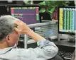  ?? — AFP ?? A Chinese investor looks at stocks prices on a monitor at a stock exchange.