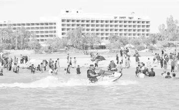  ??  ?? In this file photo taken on June 17, 2012, Iraqis swim and ride jetskis in Lake Habbaniyah.