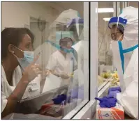  ?? (AP/Maya Alleruzzo) ?? A nurse in a sterile area confers with a colleague in the coronaviru­s ward Thursday at Barzilai Medical Center in Ashkelon, Israel.