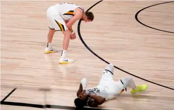  ?? AP Photo/Mark J Terrill ?? Utah Jazz’s Joe Ingles (2) and Donovan Mitchell (bottom right) sit on the floor after their 80-78 loss to the Denver Nuggets during an NBA first round playoff basketball game, on Tuesday in Lake Buena Vista, Fla.