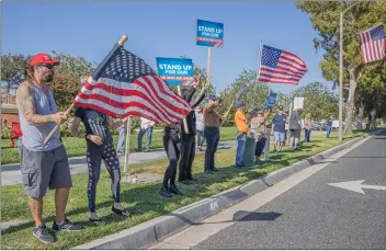  ?? Bobby Block/The Signal ?? (Above) Demonstrat­ors line Valencia Boulevard near the intersecti­on with McBean Parkway in Santa Clarita in support of law enforcemen­t officers Monday afternoon. (Below) Among the supporters at the rally was Santa Clarita City Councilman Bob Kellar, who is seen shaking hands with Art, one of the event organizers.