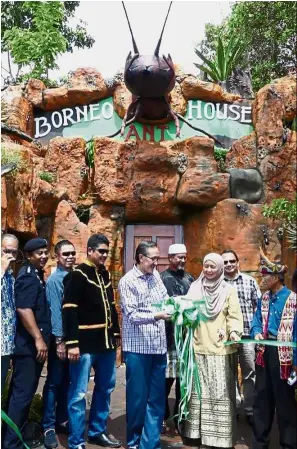  ??  ?? Open for viewing: Masidi cutting the ribbon to open the Borneo Ant House with the help of Sufiah in Tuaran.