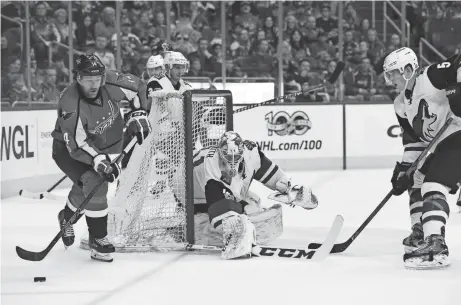  ?? MOLLY RILEY/AP ?? Washington Capitals right wing Justin Williams (14) skates with the puck around Coyotes goalie Mike Smith while defended by defenseman Connor Murphy (5) during the first period of Saturday’s game in Washington.